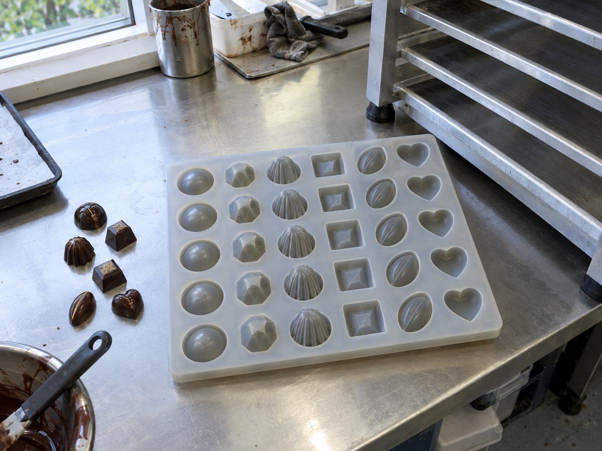 Custom silicone tasting tray with repeated bonbon shapes beside a chiller shelf