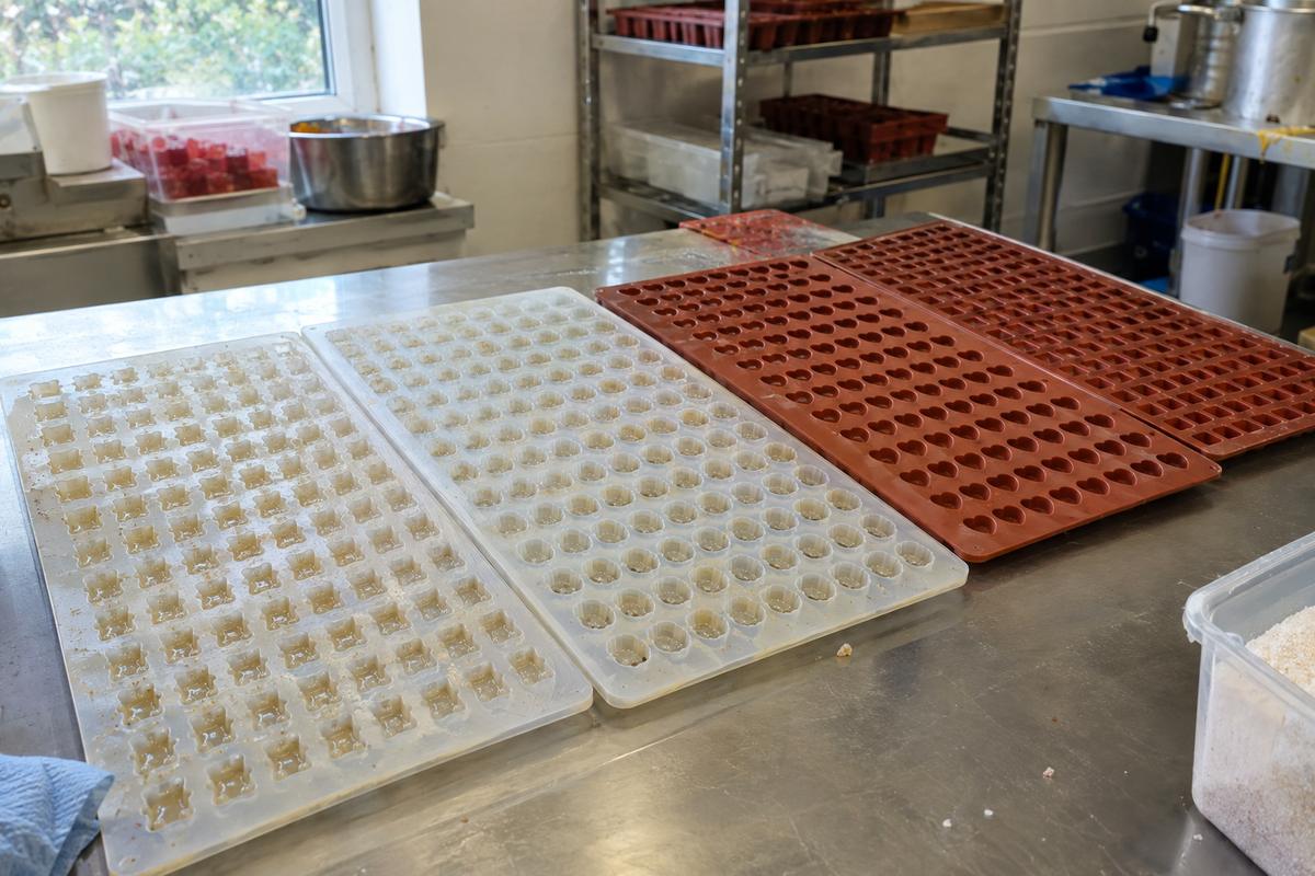 Multi-cavity silicone confectionery trays for gummies and jellies on a bench