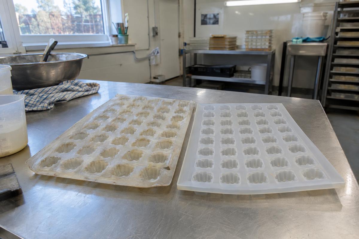 Worn silicone tray beside a matched replacement on a stainless bench