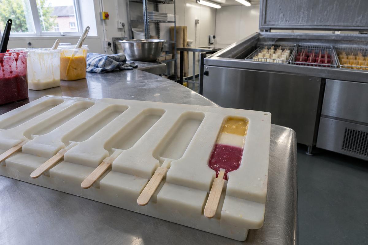 Custom silicone lolly mould with layered fill around wooden sticks