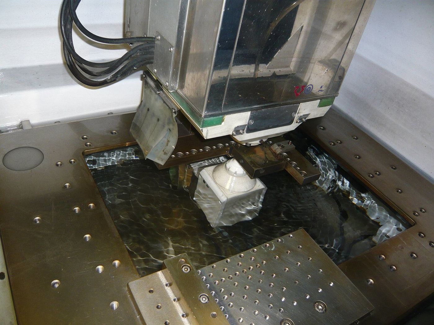 Spark-erosion machine with electrode head over the work tank.